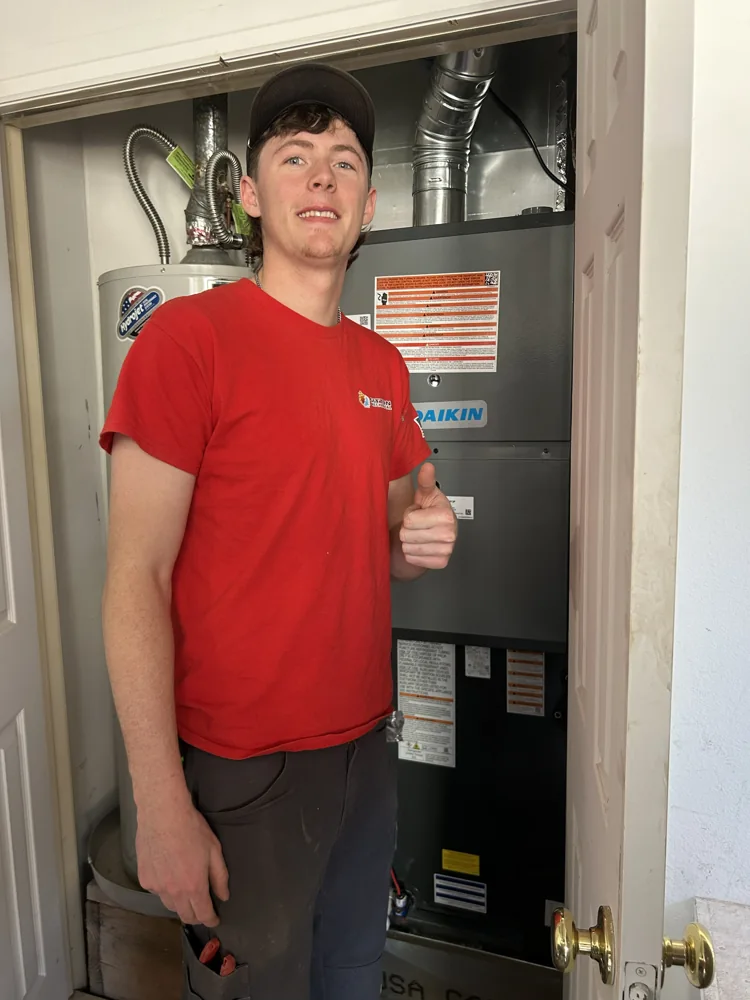 Sitton Mechanical technician beside a Daikin furnace